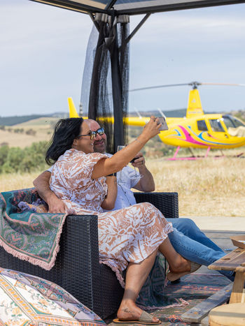 Couple enjoying wine and gourmet food in a private picnic area flown in by helicopter on an exclusive Barossa Valley luxury helicopter wine tour near Adelaide, Australia, featuring intimate and scenic aerial and ground wine tasting experiences.