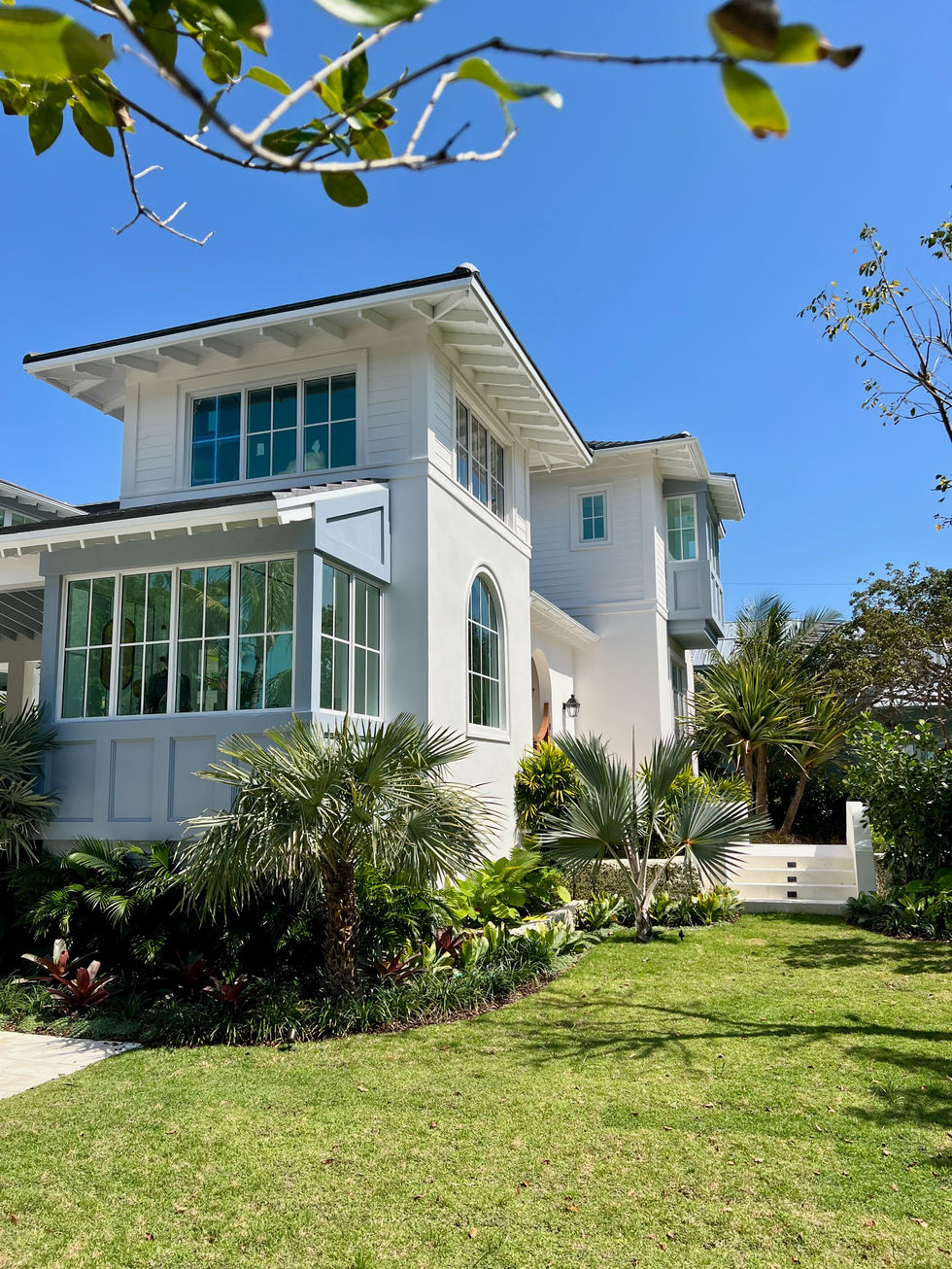 a white house with lots of windows and palm trees