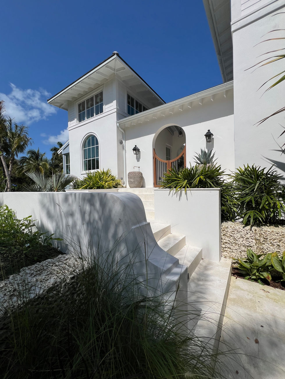 a white house with stairs leading up to the front door