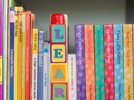 A colorful shelf of children’s books and alphabet blocks.