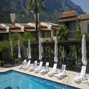 Alda Hotel courtyard surrounded by flowering gardens and traditional Cypriot stone walls.
