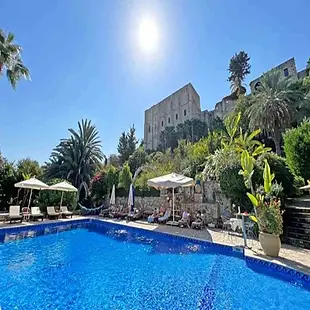Bellapais Gardens boutique hotel amid olive trees and stone pathways near the Abbey.