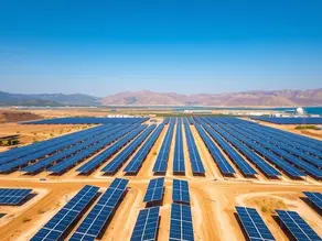 Aerial view of a large solar power plant under construction in Northern Cyprus, showing rows of solar panels across open land with mountains in the background and clear Mediterranean skies.