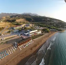 Kaplica Hotel beach resort beside golden sands and clear blue sea.