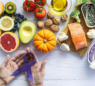 Food to prevent cancer. Two hands holding a purple ribbon concept of prevention and fight