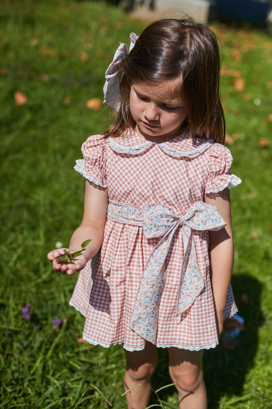 Jesusito en Vichy rosa nude con cuello bebe y puntillita en el filo. Lleva lazo de flores en cintura