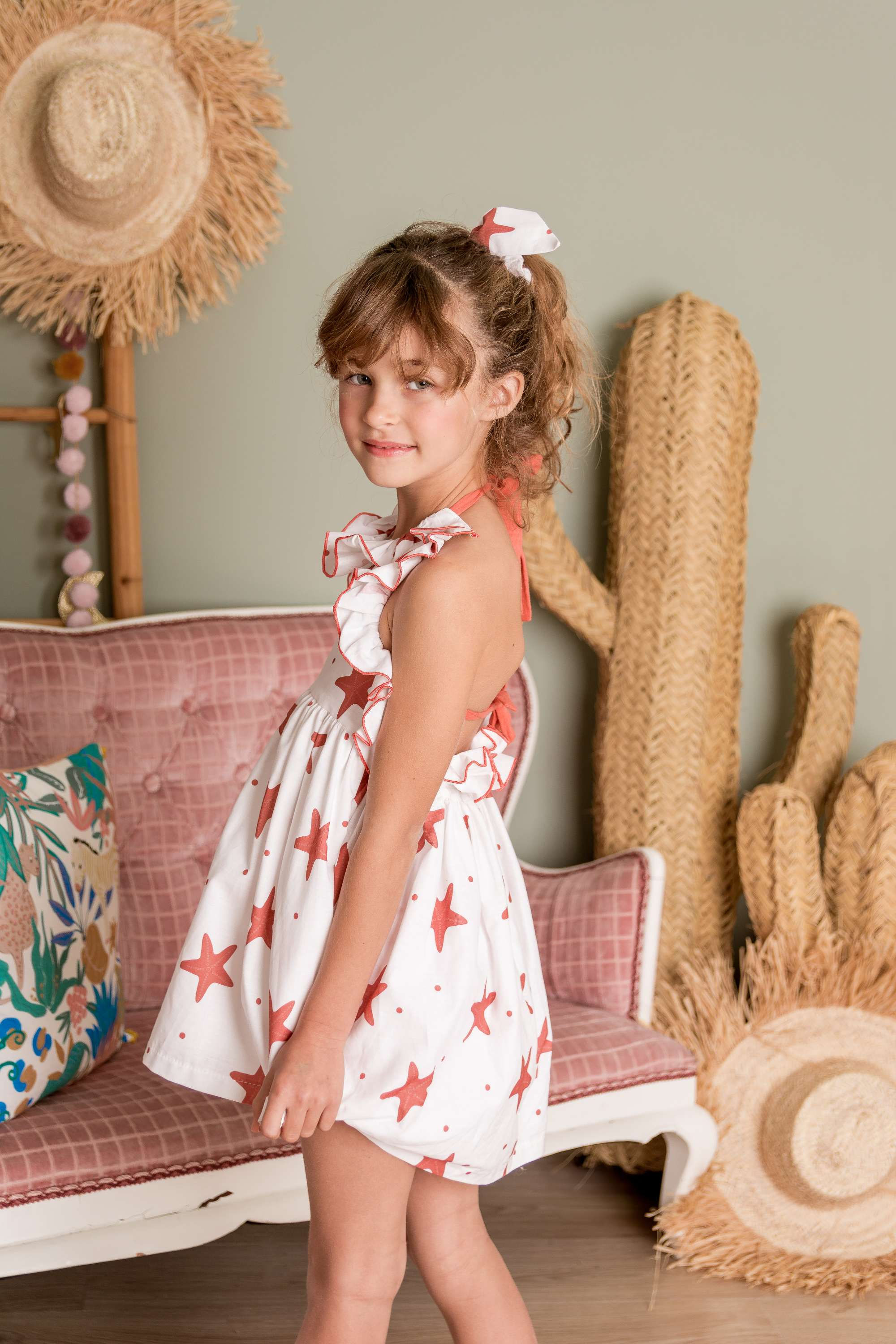 Vestido de manga a la sisa con volante desde los hombros hasta la espalda. Cuello redondo con volante