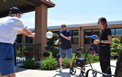 Residents playing a ball game outside with a staff member