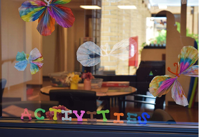 Paper butterfly crafts displayed on the activities room window