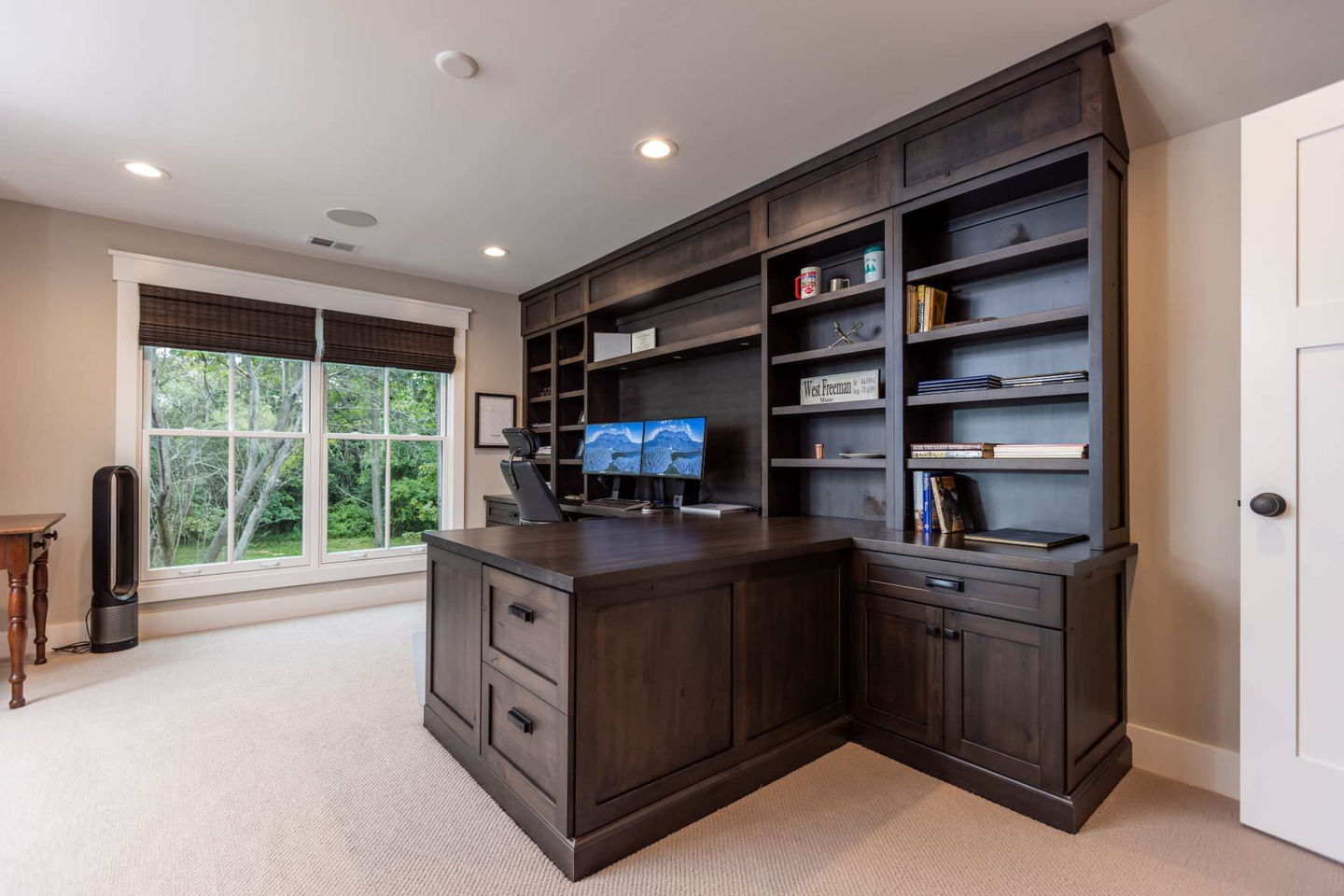 Home office with dark wood built-in shelves.