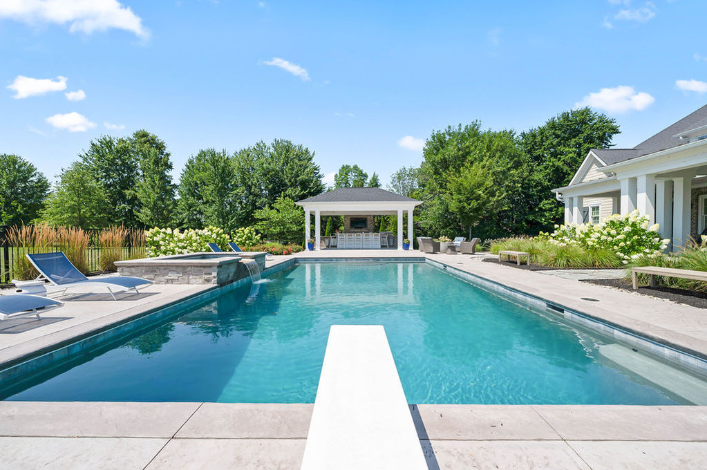 Luxurious pool with diving board and gazebo nearby.