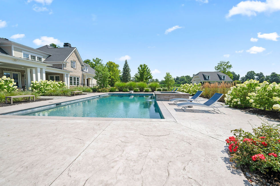 Backyard pool with lounge chairs and surrounding greenery.