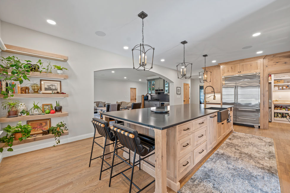 Modern kitchen with island, pendant lights, and bar stools.