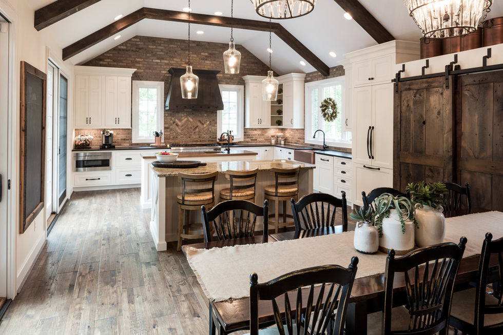 Rustic kitchen with wooden beams and modern lighting.