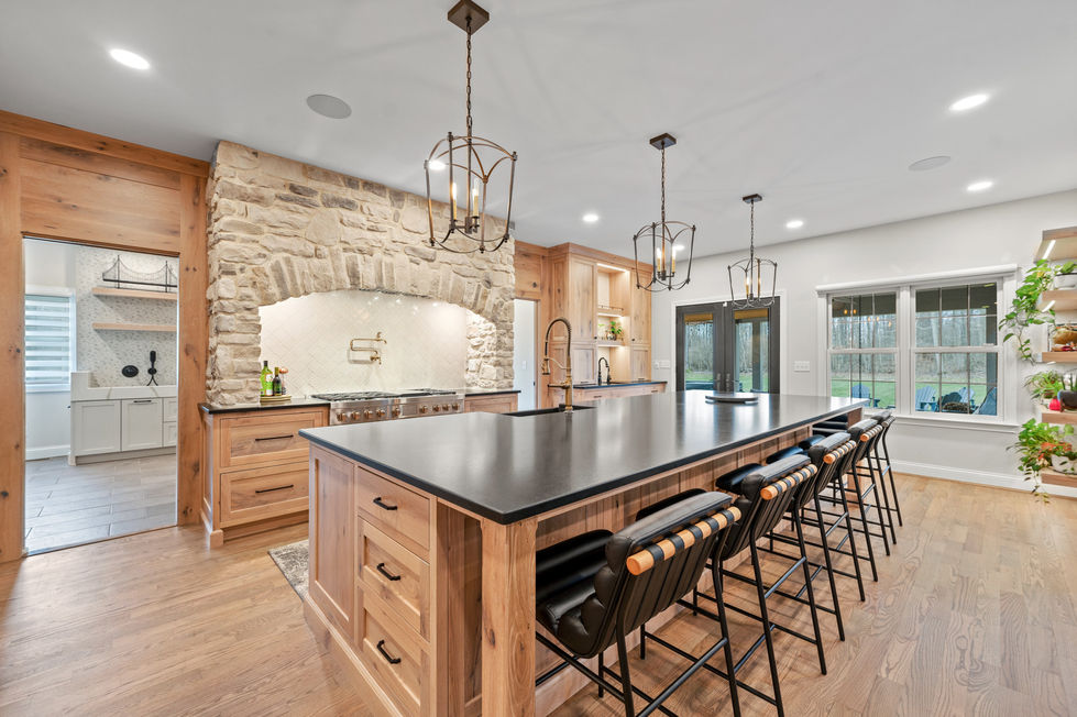 Spacious kitchen with stone wall and modern lighting.