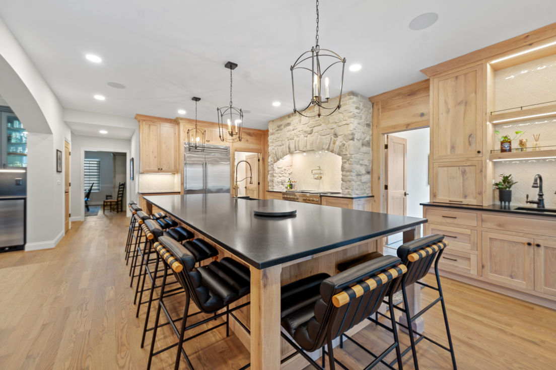 Modern kitchen with large island and stone accent wall.