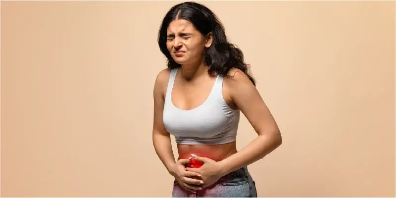 Woman clutching her lower abdomen with a pained expression.