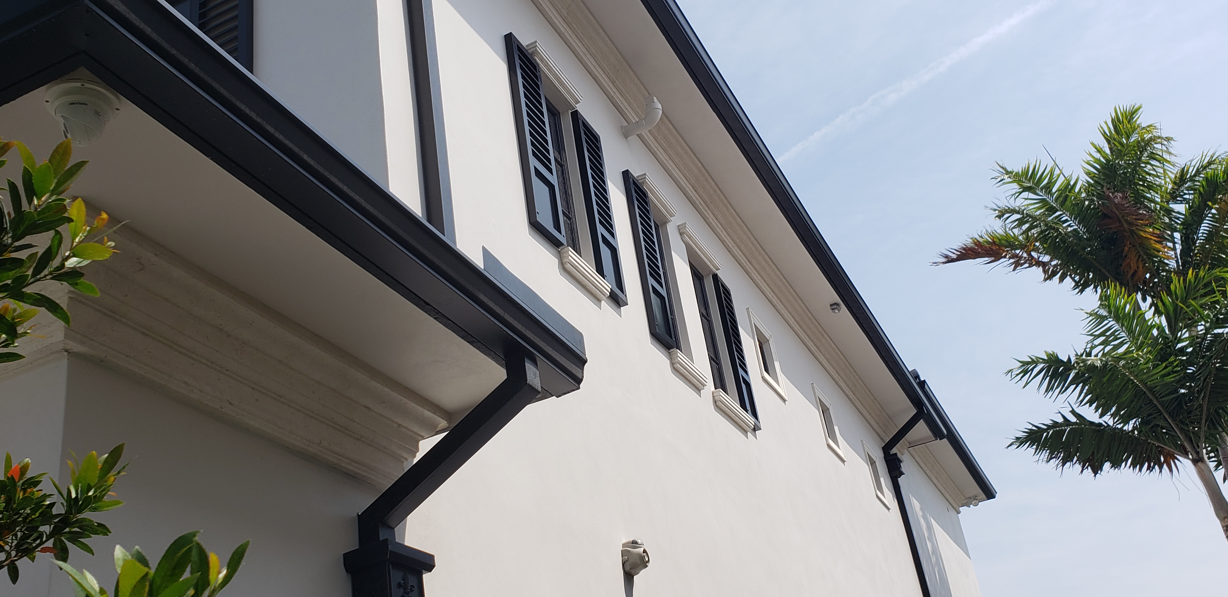 Coastal home exterior with black Bahama shutters