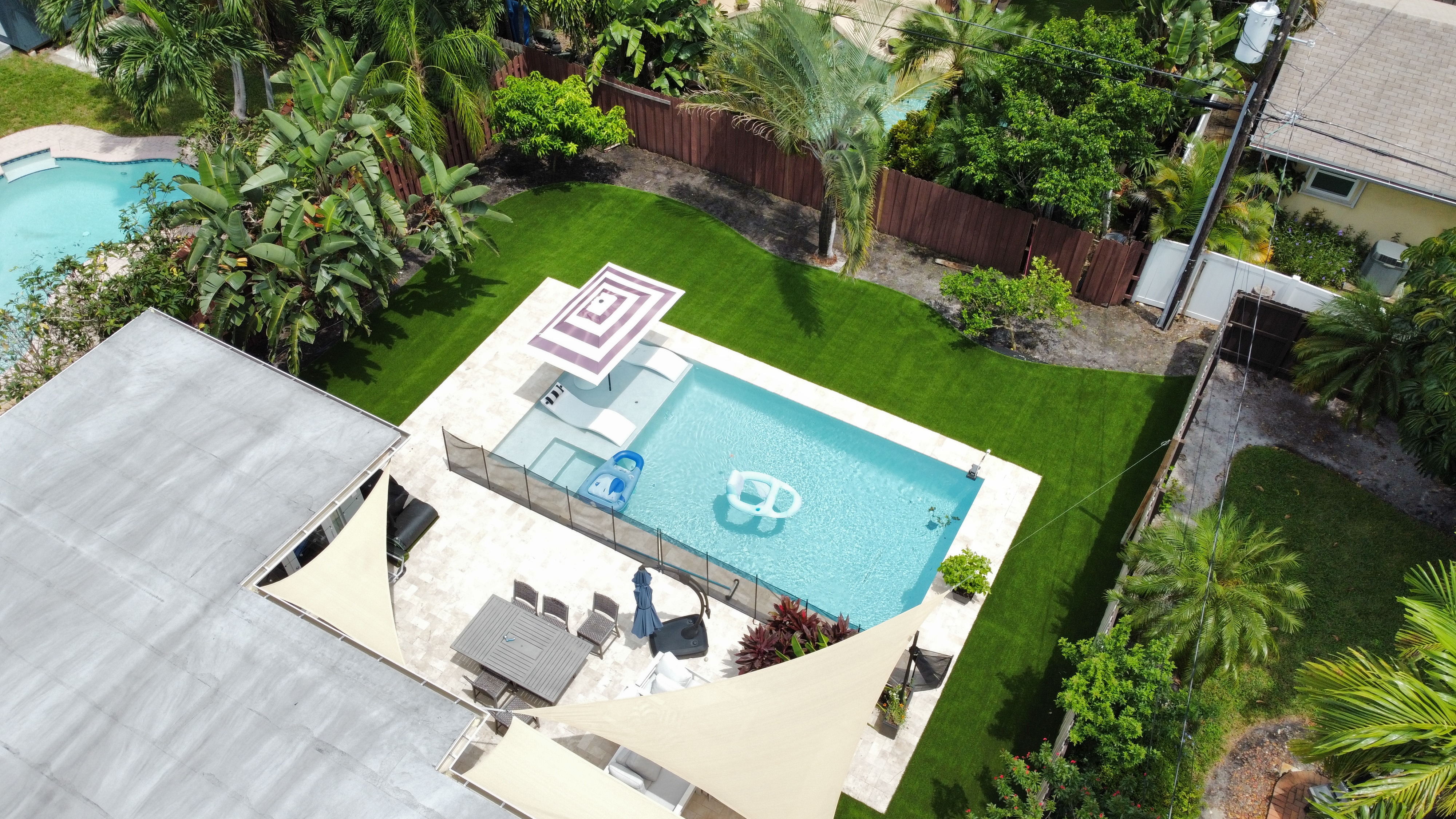 Aerial view of artificial turf backyard installation with pool