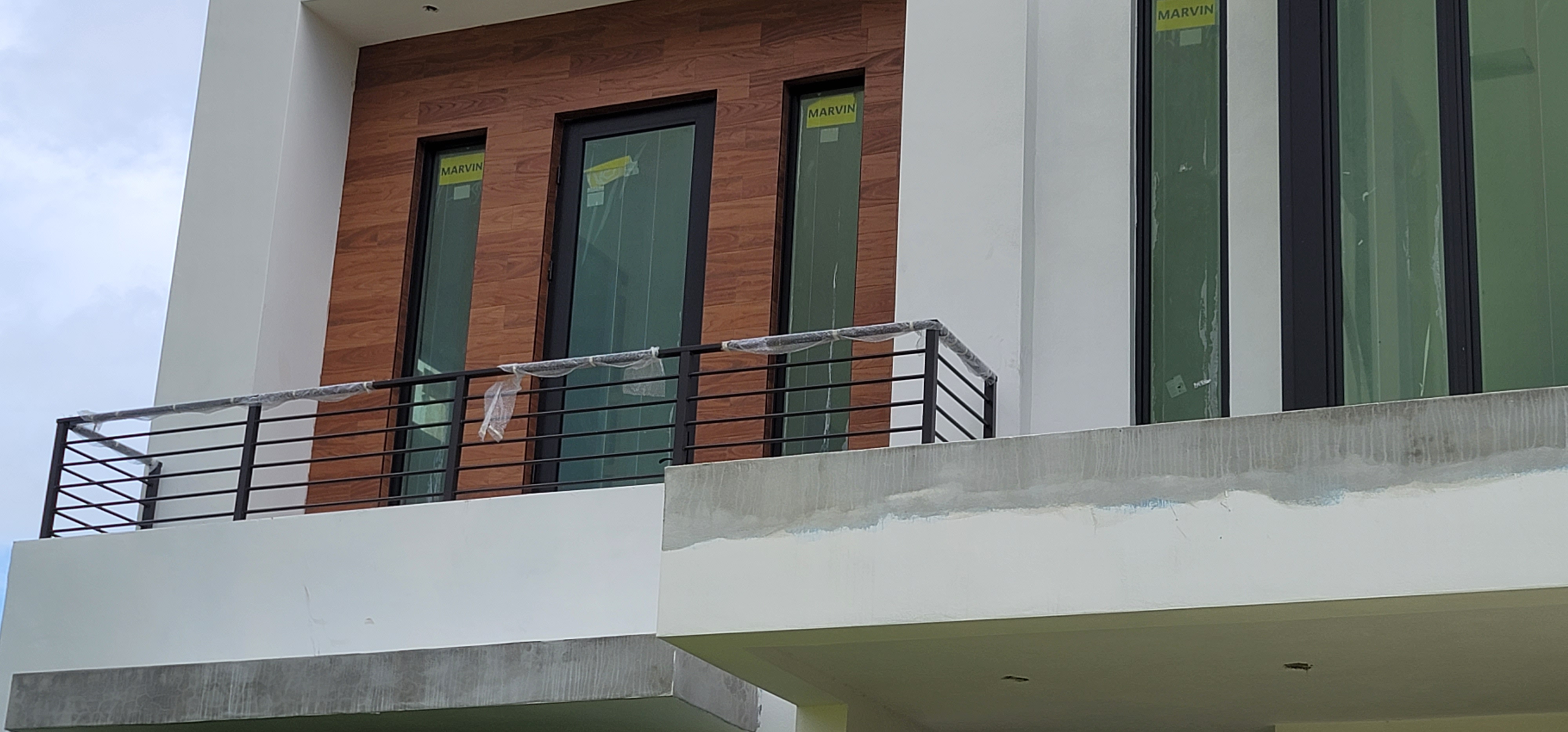 Horizontal bar balcony railing against a wood accent wall