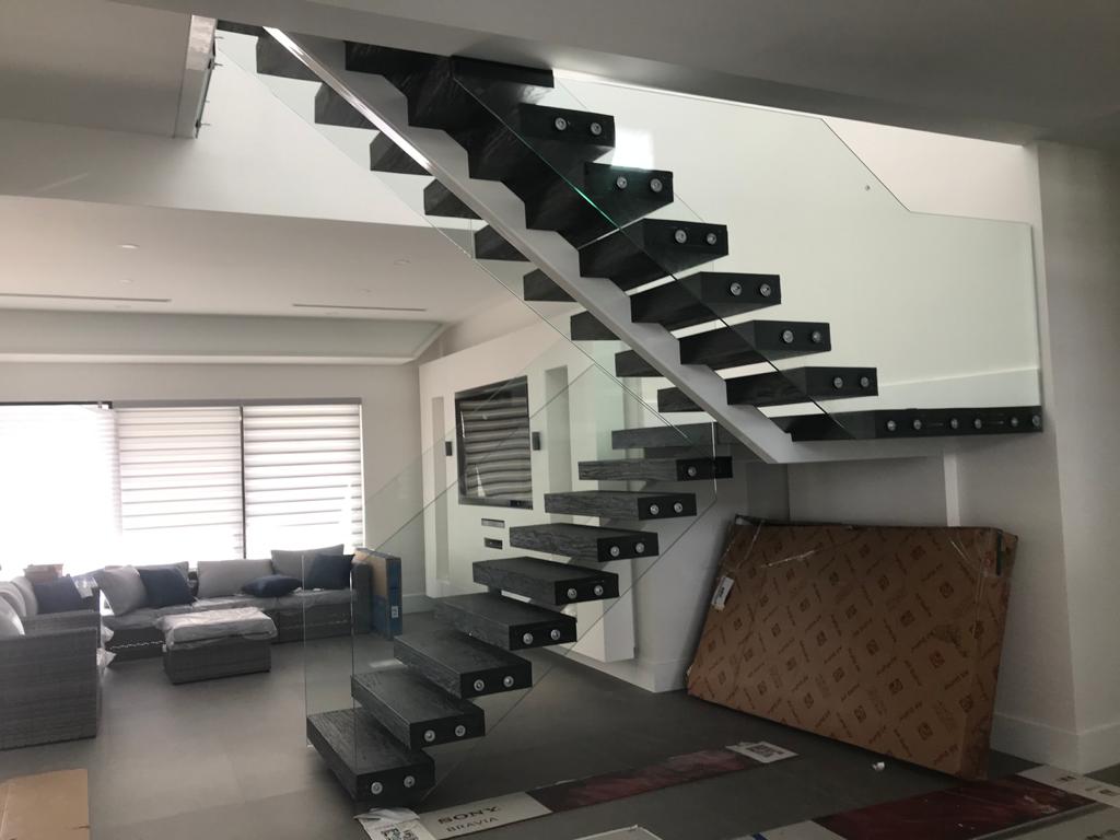 Floating steel staircase with glass railing, residential interior install