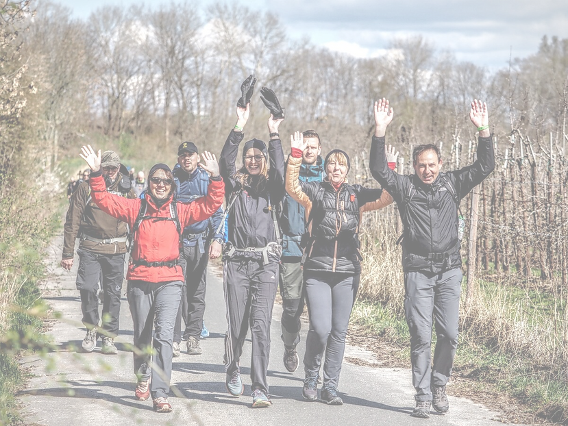 Motivierte Wanderer beim Megamarsch Hamburg heben die Hände und feiern die Challenge auf der Strecke