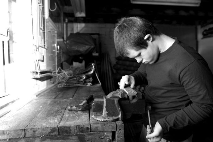 A young man working in a woodwork shop
