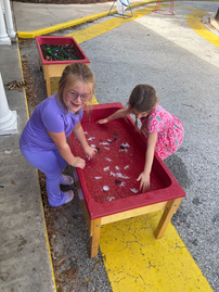 kids playing in a sensory table with ice water and plastic animals
