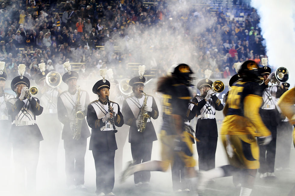 UC Berkeley band member playing clarinet as football players enter the stadium.