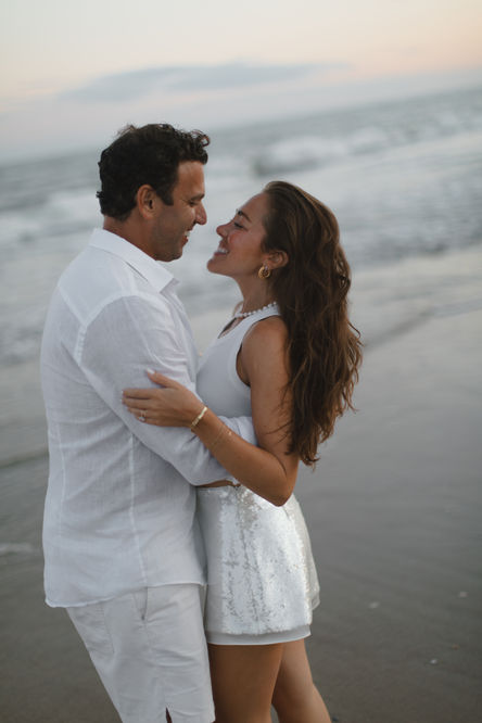 a man and a woman are hugging on the beach