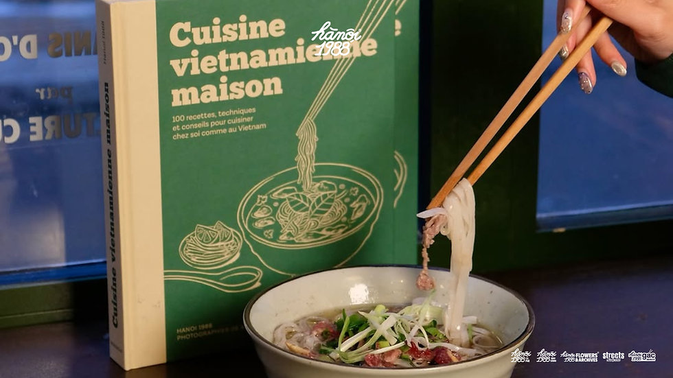 Vietnamese cookbook displayed beside a bowl of pho as a culinary souvenir from Vietnam