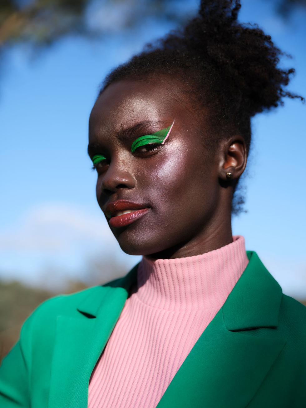 A green blazer over a pink top with green eye makeup, shot outdoors. A Moss & Spy look, with creative direction and styling by Tamarra McNaught, founder of TITO STYLE, at Riverlea Estate, Warrandyte, Victoria, Australia.