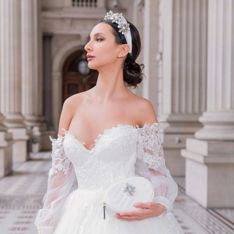 Bride in an off-shoulder Jullia Bridal lace gown with a Blinged pearl headpiece and matching clutch in the colonnade of Parliament House, Melbourne; creative direction and styling by Tamarra McNaught, founder of TITO STYLE.