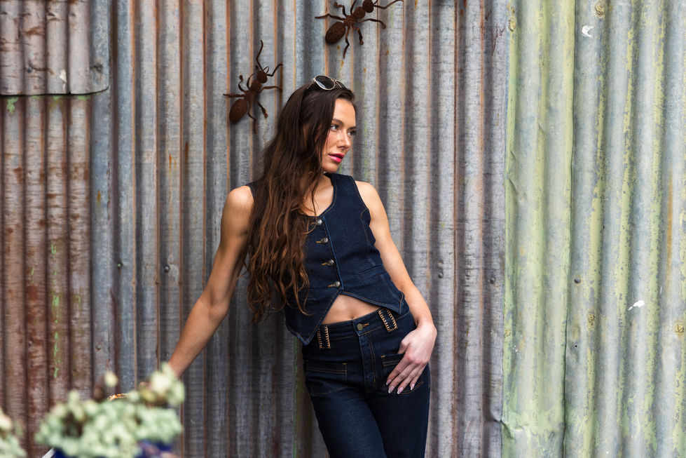 Navy tailored vest and dark denim, leaning against a rustic corrugated iron wall in Gembrook, Victoria, Australia, creative direction and styling by Tamarra McNaught, founder of TITO STYLE