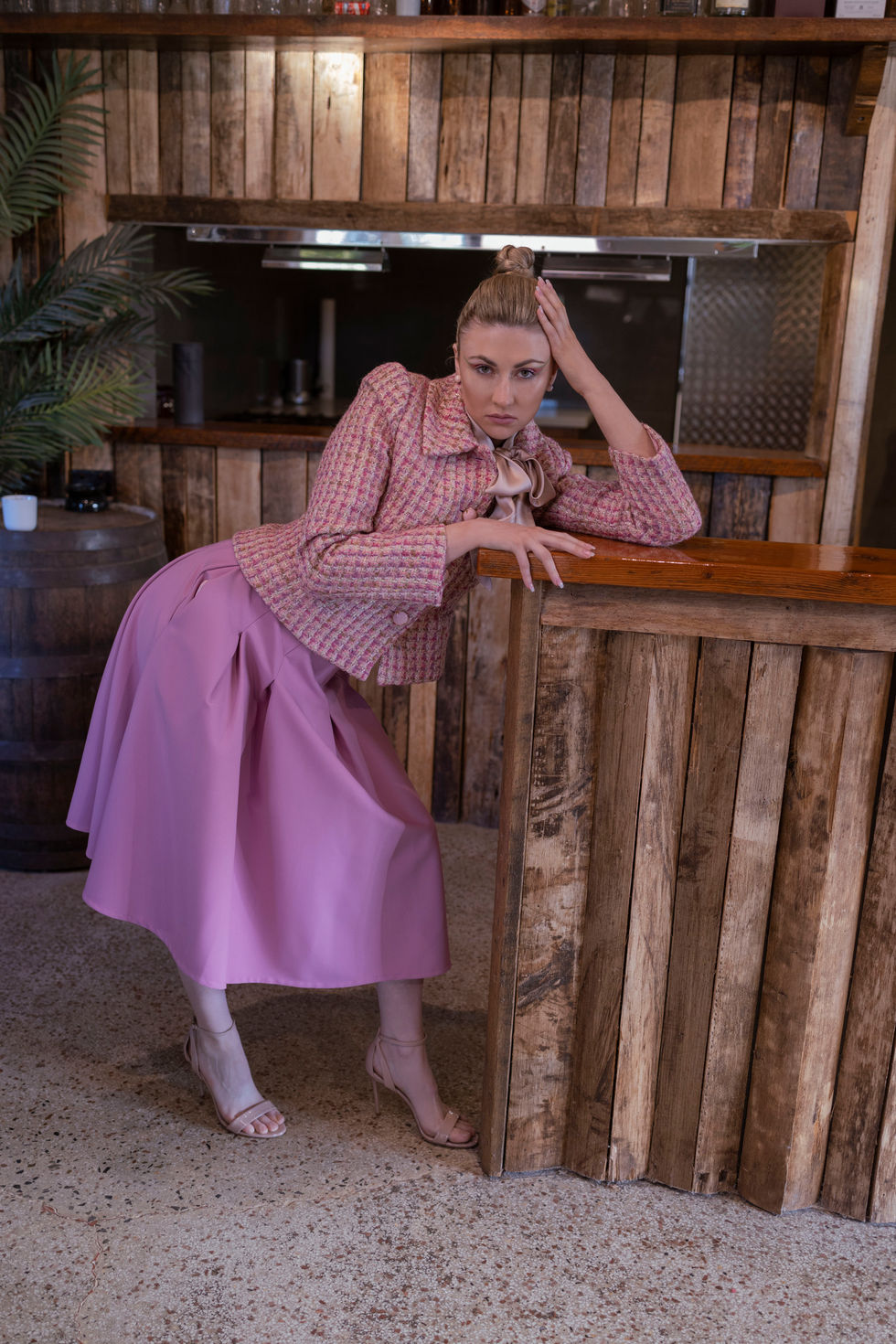 A lilac wide-leg trouser look, seated at a timber bar in the estate interior. A Moss & Spy look, with creative direction and styling by Tamarra McNaught, founder of TITO STYLE, at Riverlea Estate, Warrandyte, Victoria, Australia.