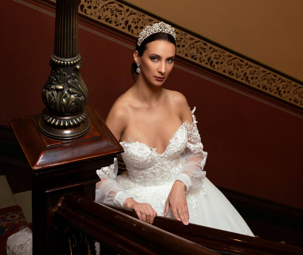 Bride in an off-shoulder Jullia Bridal lace gown and crystal tiara on an ornate timber staircase at The Hotel Windsor, Melbourne; creative direction and styling by Tamarra McNaught, founder of TITO STYLE.