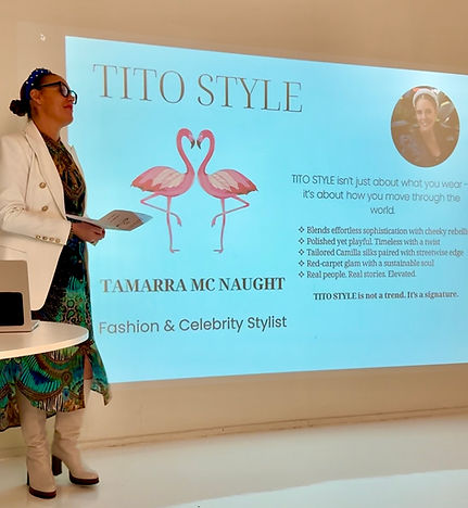 Tamarra McNaught, award-winning fashion and celebrity stylist, presents her signature styling philosophy at a TITO STYLE workshop. Standing in front of a branded slide featuring the iconic flamingo logo, Tamarra shares her approach to sustainable style, personal branding, and effortless sophistication. The presentation highlights her experience with red-carpet glam, Camilla silks, and fashion tailored for real women in business.