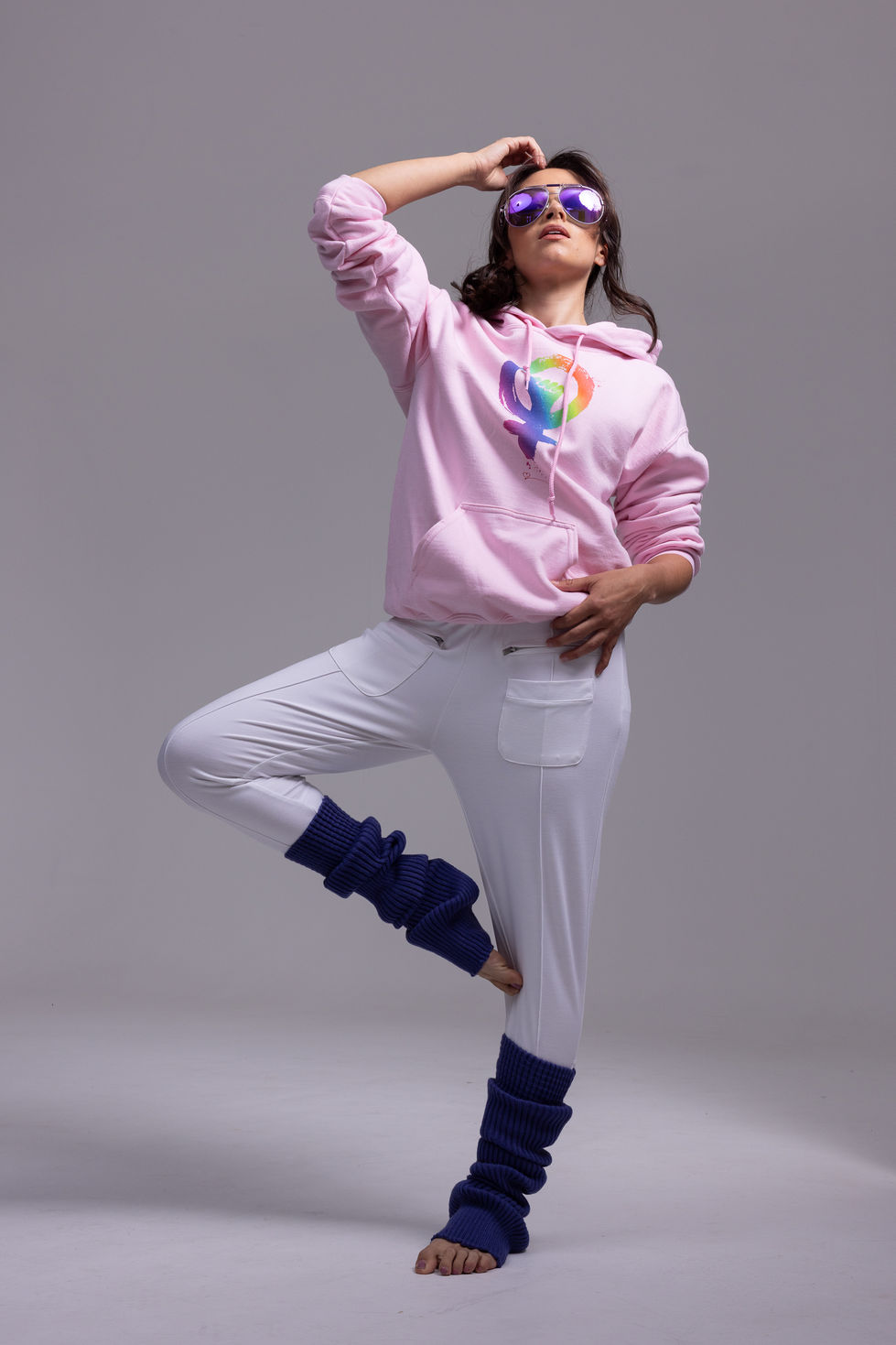 Pink The Red Heart Campaign hoodie with a rainbow symbol print, white trousers and purple Chusette leg warmers in a balanced dance pose, in Melbourne, Australia, creative direction and styling by Tamarra McNaught, founder of TITO STYLE