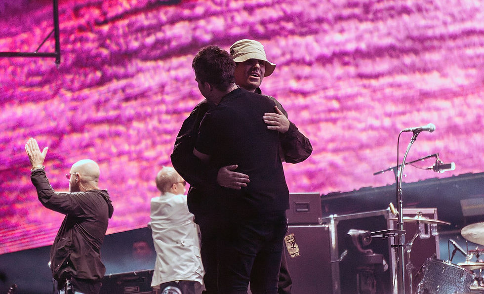 Liam and Noel Gallagher embrace on stage at Wembley Stadium, 3 August 2025
