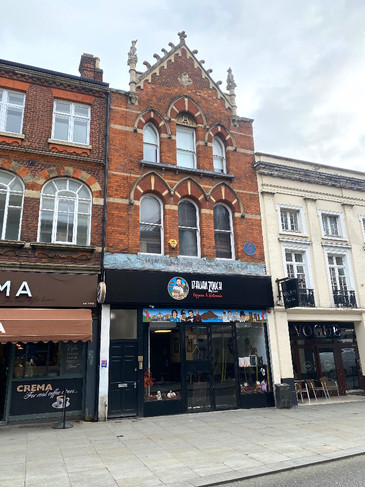 Two dog statues on the top of an historic building on Bedford's High Street.