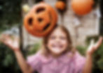 Young playful girl with her Halloween jack-o'-lantern