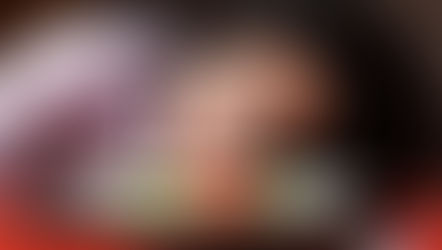 mulher escorada sobre a mesa de refeição olhando frustrada para um prato praticamente vazio, com poucas folhas de alface e tomatinhos.