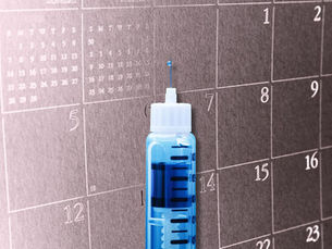 caneta emagrecedora à frente de um calendário.