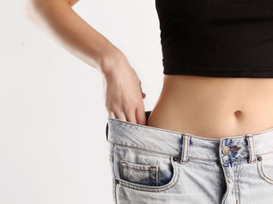 mulher usando calça jeans larga após emagrecimento
