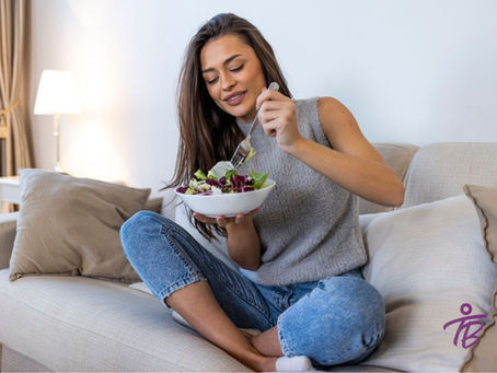 mulher no sofá comendo uma salada em um bowl