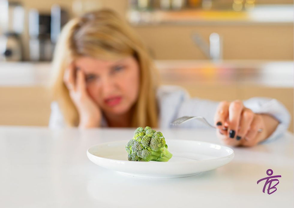mulher frustrada olhando para um prato com um brócolis.