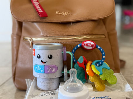 a diaper bag, baby toys, wipes, and a baby bottle