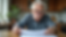 Eye-level view of a senior reviewing Medicare paperwork at a kitchen table