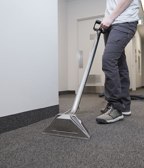 woman removing dirt from carpet with professional vacuum cleaner.jpg