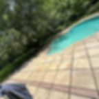 Stone tile pool deck with decorative border and trees